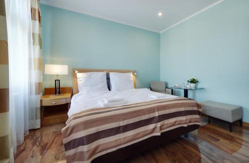 een slaapkamer met een groot bed en een gestreepte deken bij Aparthotel Katowice in Katowice