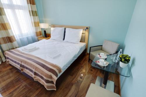 a small bedroom with a bed and a table at ApartHotel Katowice - Deluxe Rooms with King Beds, City Center, Free Wifi! in Katowice