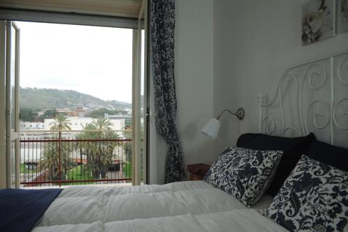 Un dormitorio con una cama y una ventana grande. en Apartment Oltremarestudios, en Nápoles