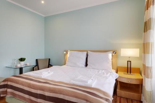 a bedroom with a bed and a table with a lamp at ApartHotel Katowice - Deluxe Rooms with King Beds, City Center, Free Wifi! in Katowice