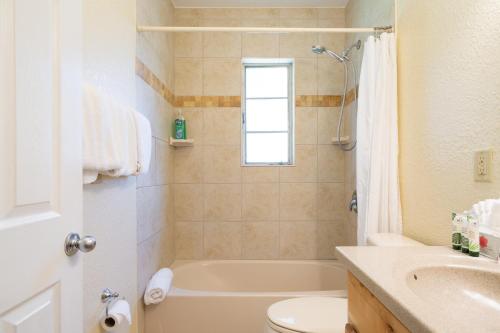 a bathroom with a tub and a toilet and a sink at Mar Bay Exclusive Suites in Safety Harbor