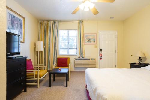 a hotel room with a bed and a television at Mar Bay Exclusive Suites in Safety Harbor