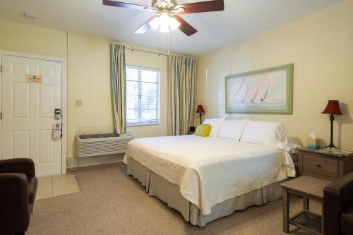 Mar Bay Exclusive Suites في سيفتي هاربور: غرفة نوم بسرير ومروحة سقف