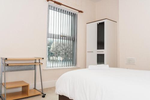 een slaapkamer met een bed en een raam bij Hanley Park House in Stoke on Trent
