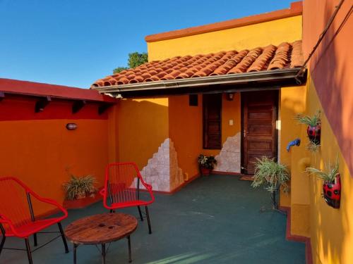 eine Terrasse mit Stühlen und einem Tisch auf einem Haus in der Unterkunft Mi lugar Vintage Hostal - calor de hogar! in Asunción