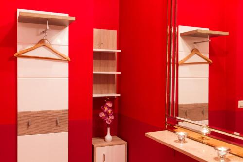 a red wall with shelves and a mirror at Hotel Spreewitz am Kurfürstendamm in Berlin