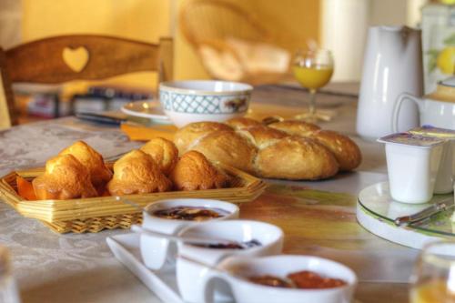 - une table avec un panier de croissants et d'autres aliments dans l'établissement Ferme du Pigeonnier, à Montceau-et-Écharnant