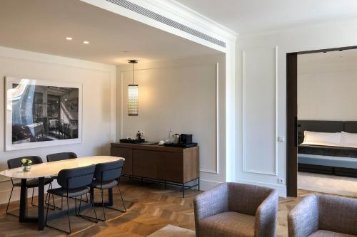a room with a table and chairs and a bed at Kozmo Hotel Suites & Spa - Small Luxury Hotels of the World in Budapest