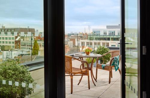 a balcony with a table and chairs and a view of a city at The Grafton Hotel in Dublin