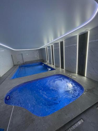 a large blue swimming pool in a building at In hotel in Kamianets-Podilskyi