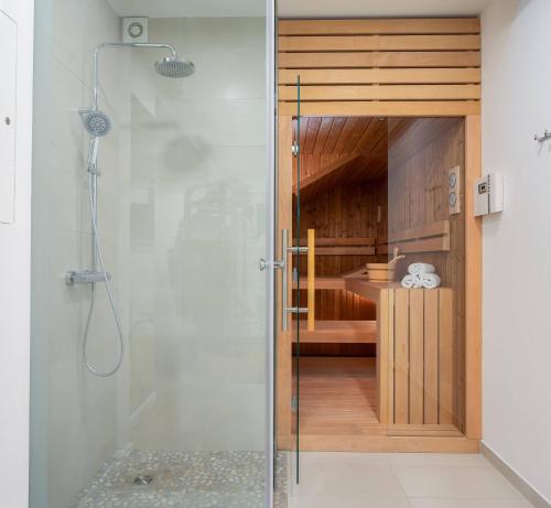 una doccia con una porta in vetro in un bagno di Luxury beachfront VILLA FLORES heated outdoor, indoor pool, whirlpool, sauna a Duće