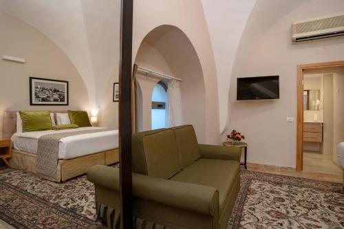 a bedroom with a bed and a chair in a room at The Sephardic House Hotel in The Jewish Quarter in Jerusalem