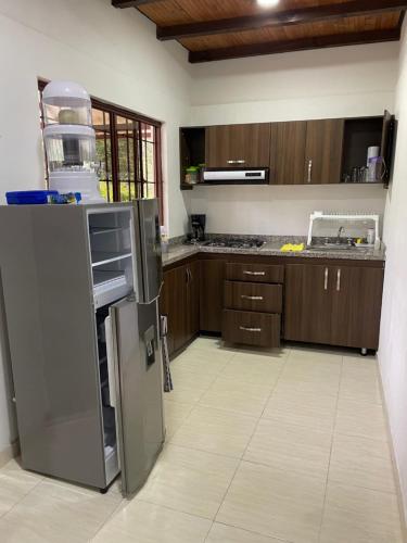 a kitchen with wooden cabinets and a stainless steel refrigerator at Finca Villa Elenita in Sasaima