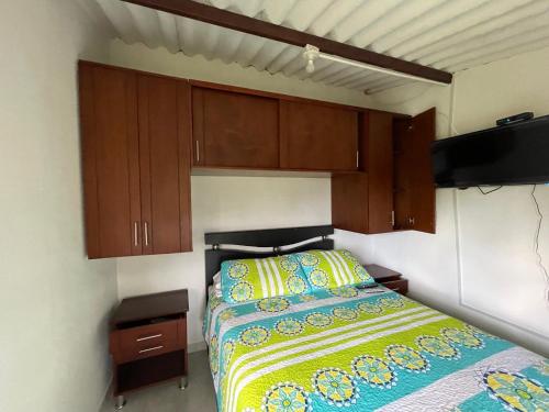 a bedroom with a bed and wooden cabinets at Finca Villa Elenita in Sasaima