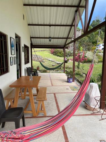a hammock in a patio with a table and chairs at Finca Villa Elenita in Sasaima
