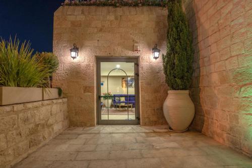 a hallway with a vase next to a brick wall at The Sephardic House Hotel in The Jewish Quarter in Jerusalem