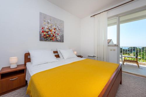 a bedroom with a yellow bed and a large window at Apartment Lena in Dubrovnik