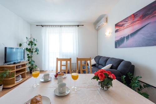 una sala de estar con una mesa con vasos de zumo de naranja en Apartment Lena, en Dubrovnik