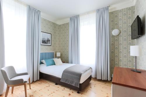 a bedroom with a bed and a desk and a chair at Fosshotel Eastfjords in Fáskrúðsfjörður