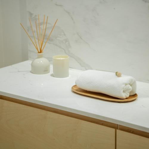 a white counter with a towel and two cups at 70's wood house in Maia
