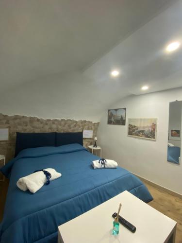 Un dormitorio con una cama azul y una mesa en Una Notte a Napoli, en Nápoles