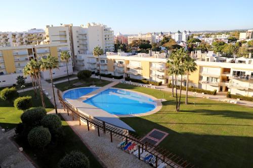 an overhead view of a swimming pool in a park with buildings at MouraPraia By Garvetur in Vilamoura