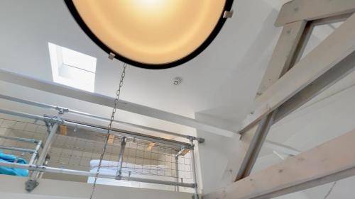 espejo grande colgando del techo en una habitación en Alta Mar Studios, en Scheveningen