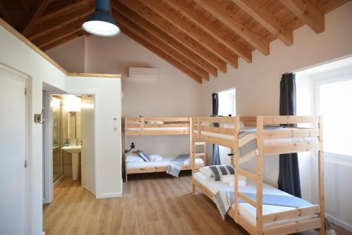 a room with two bunk beds and a bathroom at Largo Bispo Boutique Hostel in Horta