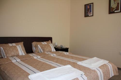 a bedroom with two beds with towels on them at Hotel Feniks Požarevac in Požarevac