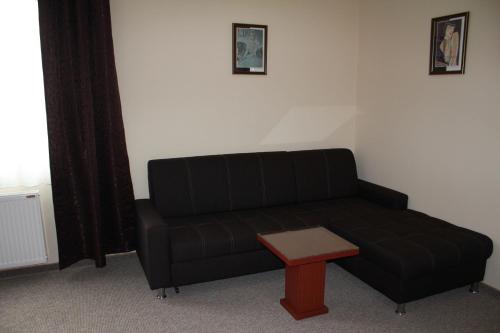 a black couch and a table in a room at Hotel Feniks Požarevac in Požarevac