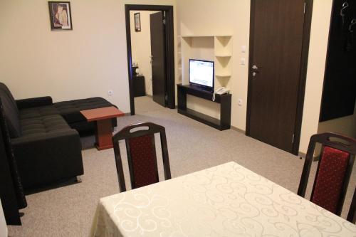 a living room with a couch and a table and a television at Hotel Feniks Požarevac in Požarevac