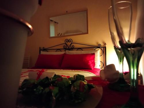 a bedroom with a bed with red pillows and flowers at Salento nel cuore in Racale
