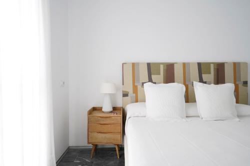 a bedroom with a bed and a nightstand with two pillows at numa I Jondo Apartments in Seville