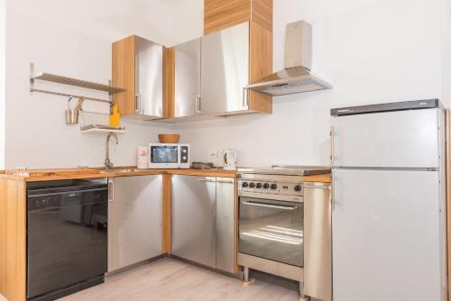 eine Küche mit Küchengeräten aus Edelstahl und Holzschränken in der Unterkunft Domus Gallina Charme e Relax in Bergamo