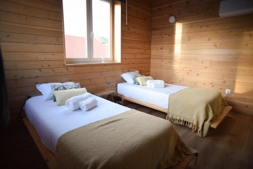 two beds in a room with wooden walls at Largo Bispo Boutique Hostel in Horta