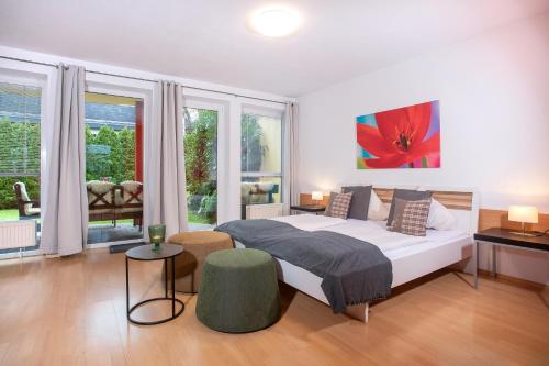 ein Schlafzimmer mit einem großen Bett und einigen Fenstern in der Unterkunft Zillertal Appartements in Fügen