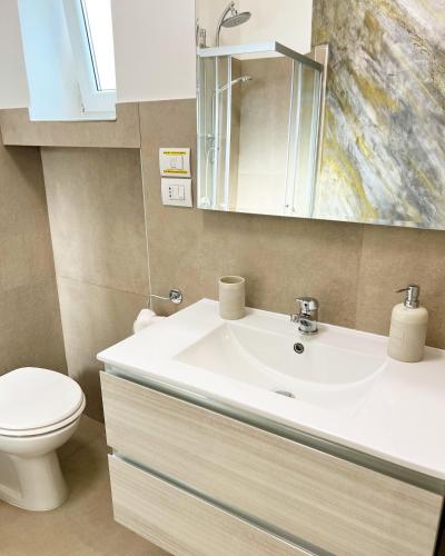 a bathroom with a sink and a toilet and a mirror at La Dimora della Fenice in Fondi