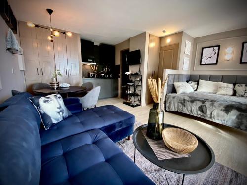 a living room with a blue couch and a table at Unique Apartment - Costa Plana in Cap d'Ail