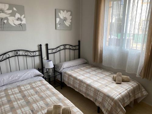 a bedroom with two beds and a window at Bungalow Alberca La Nucia in Polop