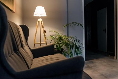 a living room with a couch and a lamp and a plant at Strzelec Noclegi in Wrocław