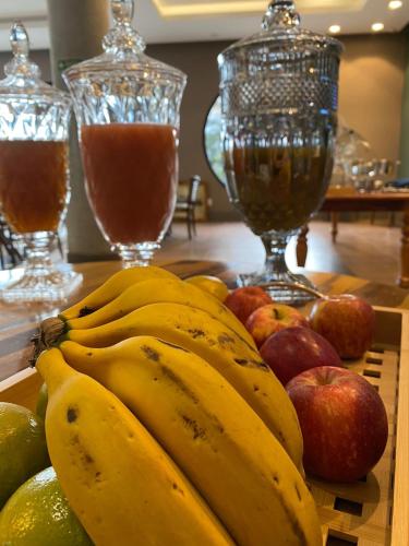 a bunch of bananas and apples on a table at KEEP SUÍTES HOTEL in Taubaté