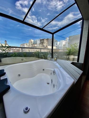 a bath tub in a room with a large window at Up Congreso Hotel in Buenos Aires