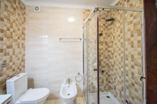 a bathroom with a shower and a toilet and a sink at Enjoy Lisbon Cascais Sintra 1200 metres to metro blue line Sintra Rail line Free Parking in Amadora