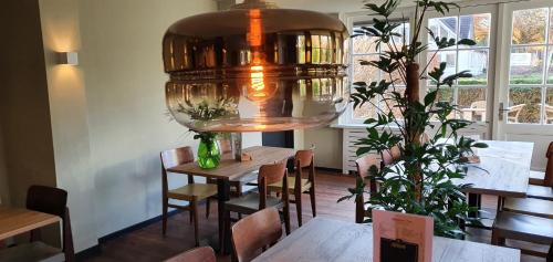 a dining room with a table and a large light at Meneer Pos in Velp