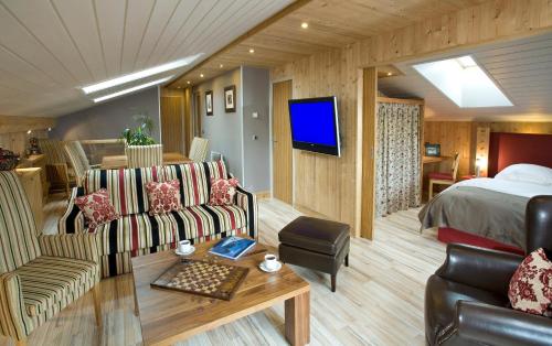 a hotel room with a bed and a living room at Le Calgary in Les Saisies