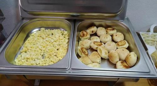Zwei Tabletts mit Kartoffeln und Reis standen auf einem Tisch. in der Unterkunft Pousada Moura Ávila in Dores de Campos