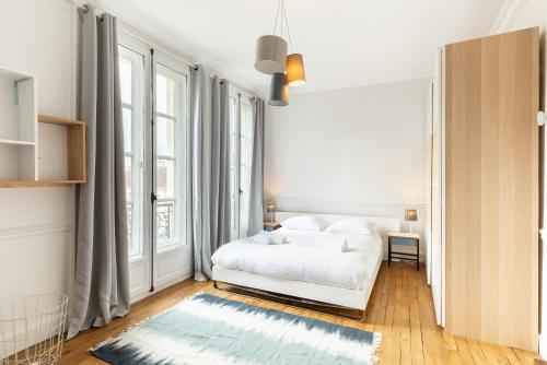 - une chambre blanche avec un lit et de grandes fenêtres dans l'établissement LE MONNAIE - Vue Cathédrale, à Rennes