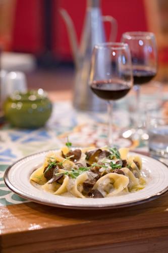a plate of pasta on a table with a glass of wine at Blue Sail Hotel in Anse Marcel 
