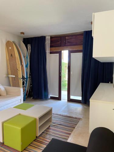a living room with a bed and a room with surfboards at App Alby KiteVillage in Uruau