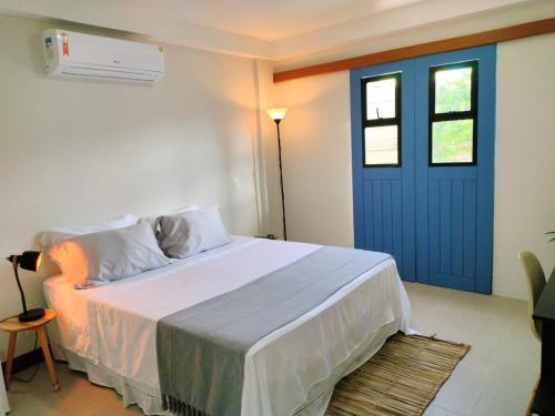 a bedroom with a bed with a blue door at Pousada VilaZinha in Vila Velha